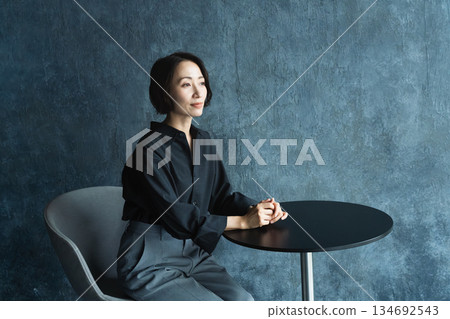 Woman sitting at a table Lifestyle image Woman sitting at a table Lifestyle image 134692543