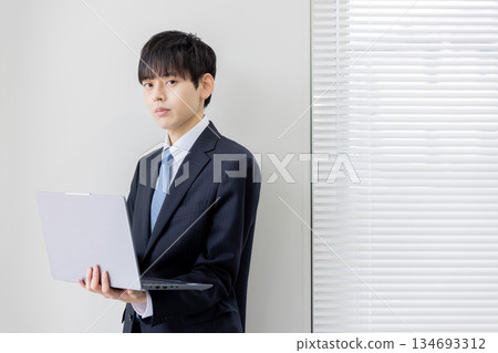 A businessman holding a computer and searching A businessman holding a computer and searching 134693312
