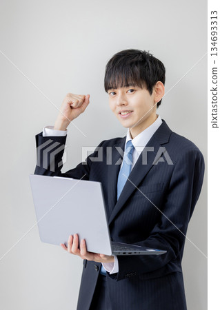 A businessman holding a computer and searching 134693313