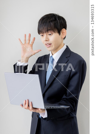 A businessman surprised by the information on his computer 134693315