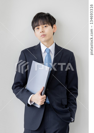 A young businessman holding a laptop computer 134693316