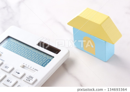 Image of a house and a calculator making a financial plan to buy the home of one's dreams Image of a house and a calculator making a financial plan to buy the home of one's dreams 134693364