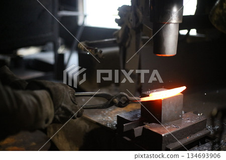 A craftsman who hammers heated materials into shapes A craftsman who hammers heated materials into shapes 134693906