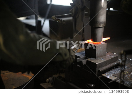 A craftsman who hammers heated materials into shapes A craftsman who hammers heated materials into shapes 134693908