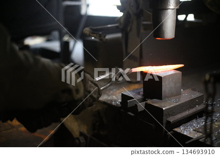 A craftsman who hammers heated materials into shapes 134693910