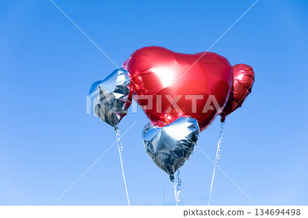 Heart balloon floating in the blue sky Heart balloon floating in the blue sky 134694498