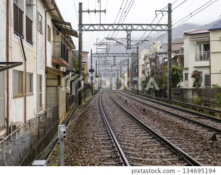 The tracks of the Nose Electric Railway's Myoken Line run through a residential area in the rain 134695194