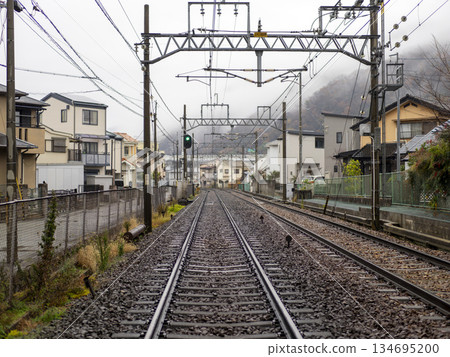 The tracks of the Nose Electric Railway's Myoken Line run through a residential area in the rain 134695200