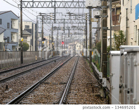 The tracks of the Nose Electric Railway's Myoken Line run through a residential area in the rain 134695201
