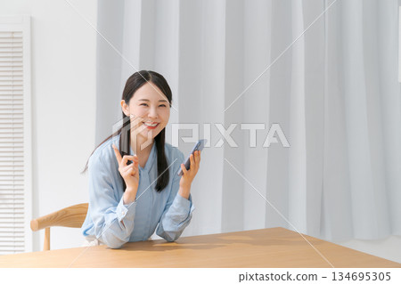 一個操作智能手機的年輕女子 134695305