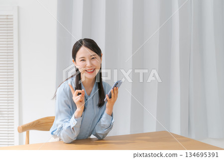 A young woman operating a smartphone A young woman operating a smartphone 134695391