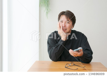 Middle-aged man operating a smartphone 134696009