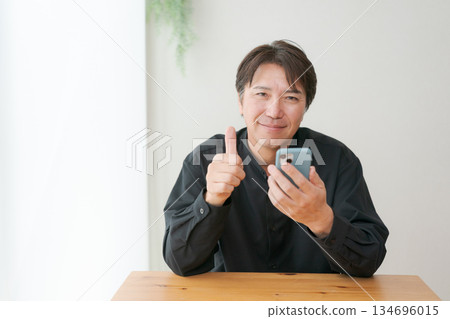 Middle-aged man operating a smartphone 134696015