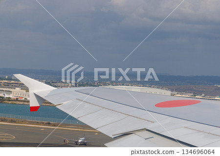 A passenger plane taking off from Honolulu Airport, with the runway and plane visible below A passenger plane taking off from Honolulu Airport, with the runway and plane visible below 134696064