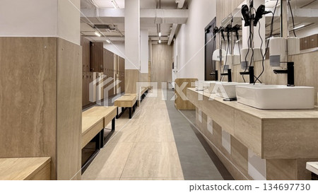 Modern gym locker room with sinks and lockers 134697730