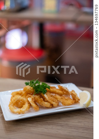 Close-up photo of Fried Squid or Calamari with lemon served on plate. 134697769