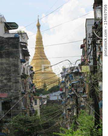 The Gold Dome of Shwedagon Pagoda behind residential buildings in Yangon The Gold Dome of Shwedagon Pagoda behind residential buildings in Yangon 134697956