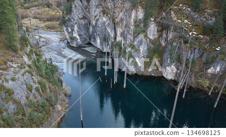 Aerial view of serene river surrounded by rocky cliffs and autumn foliage 134698125