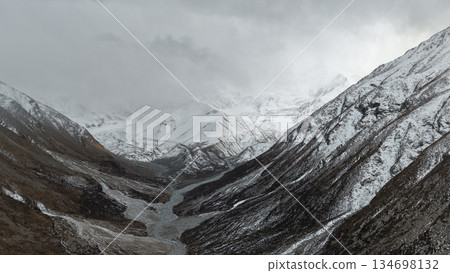 Snowy mountain valley landscape with dramatic clouds and river Snowy mountain valley landscape with dramatic clouds and river 134698132
