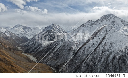 Majestic snow-capped mountains under dramatic cloudy sky landscape Majestic snow-capped mountains under dramatic cloudy sky landscape 134698145