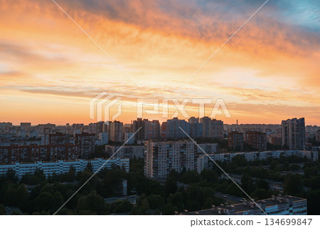 Sunset over urban landscape with vibrant colors illuminating buildings in city skyline Sunset over urban landscape with vibrant colors illuminating buildings in city skyline 134699847