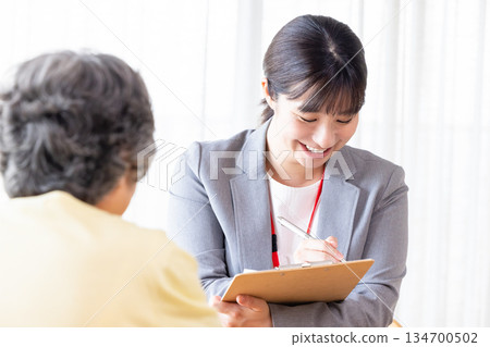 Businesswoman explaining to senior woman 134700502