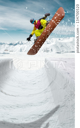 Handmade collage. Snowboarder flying over snow park jump with mountains background. 134700520
