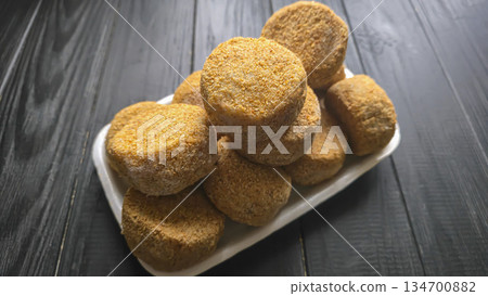 Freshly frozen breaded fish cakes. Round, semi-finished products, ready to cook. Freshly frozen breaded fish cakes. Round, semi-finished products, ready to cook. 134700882