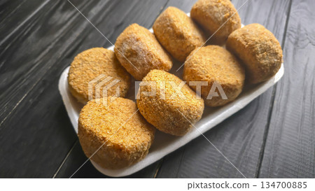 Freshly frozen breaded fish cakes. Round, semi-finished products, ready to cook. Freshly frozen breaded fish cakes. Round, semi-finished products, ready to cook. 134700885