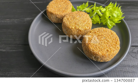 Freshly frozen breaded fish cakes. Round, semi-finished products, ready to cook. Freshly frozen breaded fish cakes. Round, semi-finished products, ready to cook. 134700887