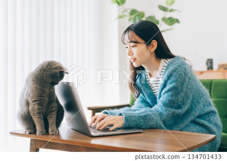 A cat peeking at a woman's computer A cat peeking at a woman's computer 134701433