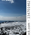 Wide snowy mountain view with blue sky and rocky peaks in winter. 134701462