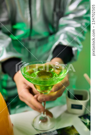 Vibrant lime cocktail presentation, Bartender displays colorful drink elegantly, Focus on bartender presenting vibrant green drink in stylish setting with soft lighting Vibrant lime cocktail presentation, Bartender displays colorful drink elegantly, Focus on bartender presenting vibrant green drink in stylish setting with soft lighting 134702505