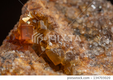 Stone with glowing orange crystals in rocky environment Stone with glowing orange crystals in rocky environment 134703020