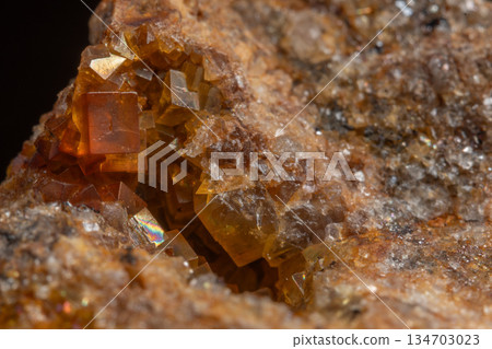 Stone with glowing orange crystals in rocky environment Stone with glowing orange crystals in rocky environment 134703023