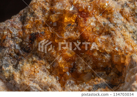Stone with glowing orange crystals in rocky environment Stone with glowing orange crystals in rocky environment 134703034