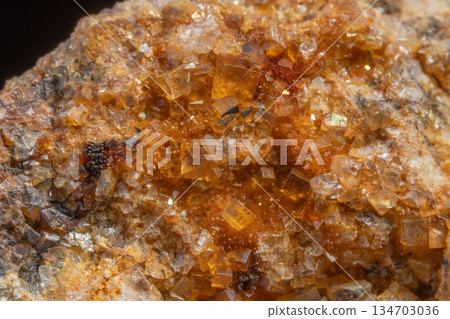 Stone with glowing orange crystals in rocky environment 134703036