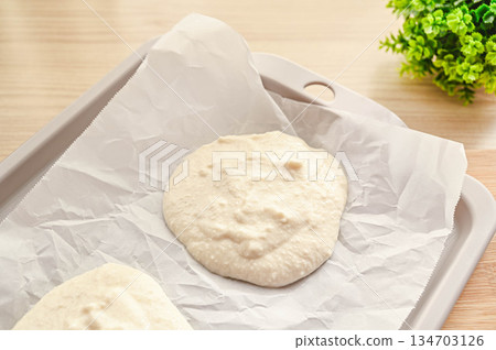 將豆腐麵包麵團放在烤盤上。 將豆腐麵包麵團放在烤盤上。 134703126