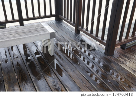 An outdoor wooden deck wet with rain. Image of wet wood. An outdoor wooden deck wet with rain. Image of wet wood. 134703418