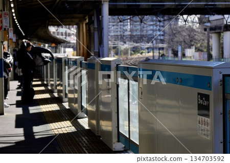 Morning station platform and salaryman putting on a jacket Morning station platform and salaryman putting on a jacket 134703592