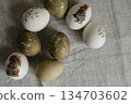 Easter holiday. Painted olive-colored eggs on a linen tablecloth. Easter decoration. 134703602