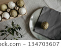 Easter holiday. Painted olive-colored eggs on a linen tablecloth. Easter decoration. 134703607