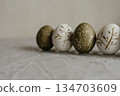 Easter holiday. Painted olive-colored eggs on a linen tablecloth. Easter decoration. 134703609