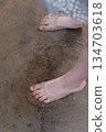 bare feet in the sea. Sand on the beach. Girl walking on the beach 134703618