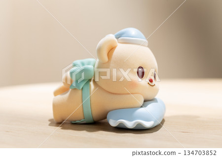 ButterBear Art Toy Rests on Blue Pillow in Playful Display 134703852