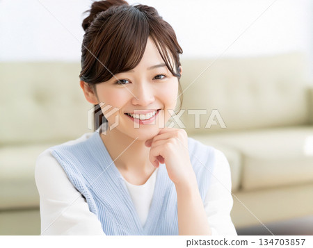 一位面帶微笑的年輕日本女子在房間裡放鬆休息 134703857