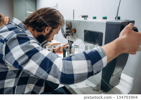 People are working by the sewing machines indoors 134703904