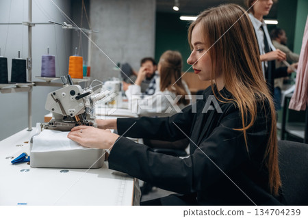 Job of clothing production. People are working by the sewing machines indoors 134704239