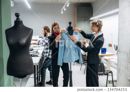 Clothing production. People are working by the sewing machines indoors 134704253