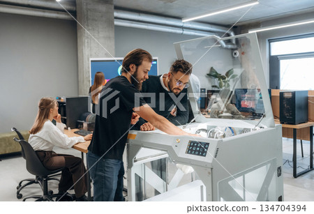 Communication, finished printed object. People are in the office by the 3d printer Communication, finished printed object. People are in the office by the 3d printer 134704394